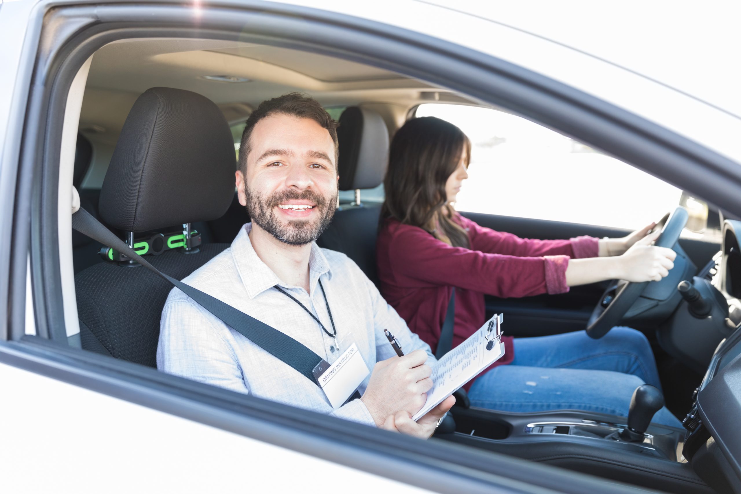 Content professional holding clipboard while woman driving car